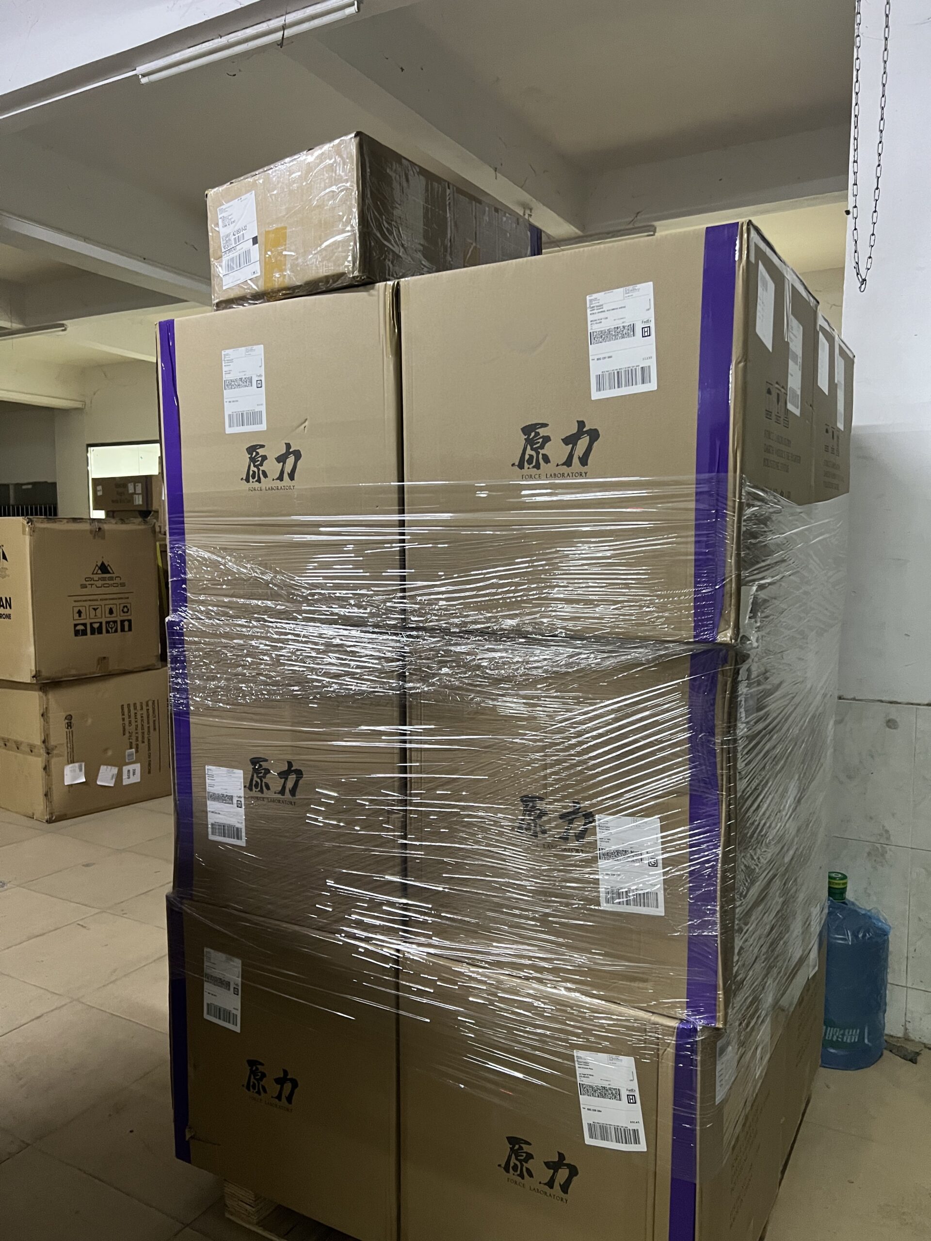 Wrapped cartons secured with purple bands on a warehouse pallet